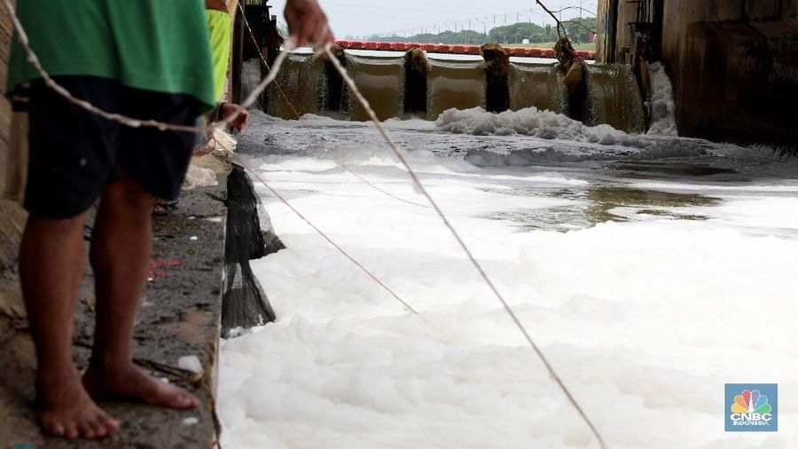 Sejumlah warga banyak menghabiskan waktu mereka dengan mencari ikan menggunakan jala di Pintu Air Weir 3 Marunda dengan kondisi air berbusa limbah rumah tangga.