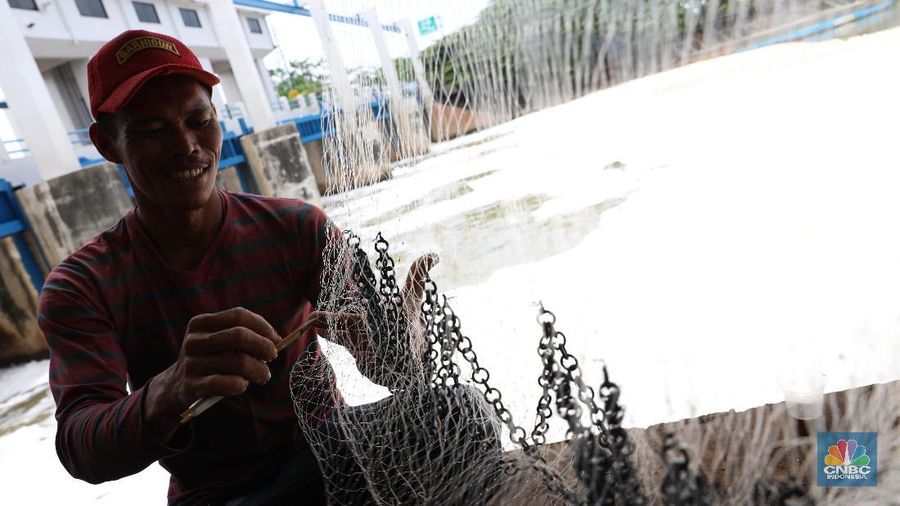 Sejumlah warga banyak menghabiskan waktu mereka dengan mencari ikan menggunakan jala di Pintu Air Weir 3 Marunda dengan kondisi air berbusa limbah rumah tangga.