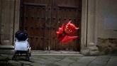 Balon merah diikatkan pada kereta dorong anak ketika festival Tamborrada di hari San Sebastian berlangsung. Saat festival itu, orang-orang berpakaian seperti prajurit Napoleon dan tampil dalam ajang bermain drum 24 jam. Festival ini berlangsung di kota San Sebastian, Spanyol. (REUTERS/Vincent West)