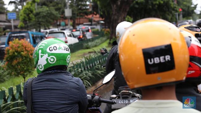 Pengendara ojek online sedang mengantarkan pelanggannya (ilustrasi ojek online)