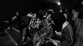Penyandang tuna netra menikmati film yang disajikan dengan ditemani oleh para relawan. Satu relawan menemani satu penyandang tuna netra. (ANTARA FOTO/Rivan Awal Lingga/18.)