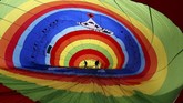 Seorang partisipan menyiapkan balon terbang dalam pekan Balon Terbang Internasional di Chateau-d'Oex, Swiss. (REUTERS/Stefan Wermuth)
