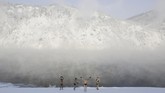 Anggota klub renang musim dingin Dolphin sedang pemanasan di tepian sungai Yenisei, kota Divnogorsk, Rusia, dengan suhu udara mencapai minus 31 derajat celcius. (REUTERS/Ilya Naymushin)