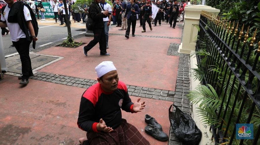 Ratusan buruh melakukan aksi jalan mundur menuju Istana Negara di Jalan. Medan Merdeka, Jakarta Pusat, Selasa (6/2/2018). Mereka melakukan aksi untuk menuntu tiga hal yaitu turunkan harga beras dan listrik, tolak kebijakan upah murah dan pilih calon pemimpin yang amanah dan pro buruh dan anti PP 78/2015.