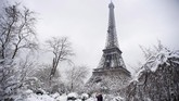 Menara Eiffel sempat ditutup sementara. Dalam foto ini terlihat bagaimana ikon Perancis itu dan taman Champ de Mars yang berada di sekitarnya diselimuti salju. (AFP Photo/Alain Jocard)