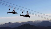 Orang-orang menggunakan tali penyebrangan terpanjang di dunia yang terdapat di Ras al-Khamiah di Gunung Jabal Jais, Uni Emirat Arab. (REUTERS/Ahmed Jadallah)