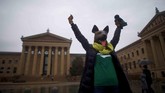 Seseorang mengenakan topeng anjing sebagai penanda ia pendukung tim underdog (kuda hitam). Ia berada di luar Museum Seni Philadelphia sebelum pertandingan Super Bowl LII antara Philadelphia Eagles dan New England Patriots di Philadelphia, Pennsylvania, AS. (REUTERS/Mark Makela)
