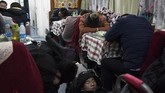 Namun, tak ada yang mengeluh. Mereka menghabiskan waktu dengan bermain ponsel, berbagi makanan, atau sekadar bersenda gurau bersama teman sebangku. (AFP Photo/Fred Dufour)