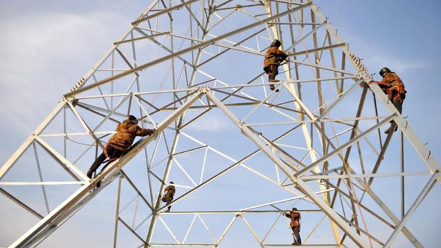 Employees work on an electrical tower in Qingdao, China January 26, 2018. Picture taken January 26, 2018. REUTERS/Stringer ATTENTION EDITORS - THIS IMAGE WAS PROVIDED BY A THIRD PARTY. CHINA OUT. NO COMMERCIAL OR EDITORIAL SALES IN CHINA.