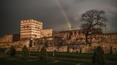 Pelangi terlihat di tembok Byzantium yang bersejarah, setelah hujan badai menerpa Distrik Topkapi, Istanbul, Turki. (AFP PHOTO / OZAN KOSE)