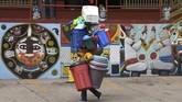 Seorang penjual membawa perabot plastik di jalanan kota Tegucigalpa, Honduras. (AFP PHOTO / ORLANDO SIERRA)