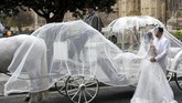 Sepasang pengantin berdiri dekat kereta kuda di luar Istana Westminster di London Tengah, Inggris. (REUTERS/Peter Nicholls)