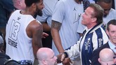 Pemain Team LeBron Paul George bersalaman dengan aktor Arnold Schwarzenegger di sela pertandingan NBA All Star 2018. (Jayne Kamin-Oncea/Getty Images/AFP)