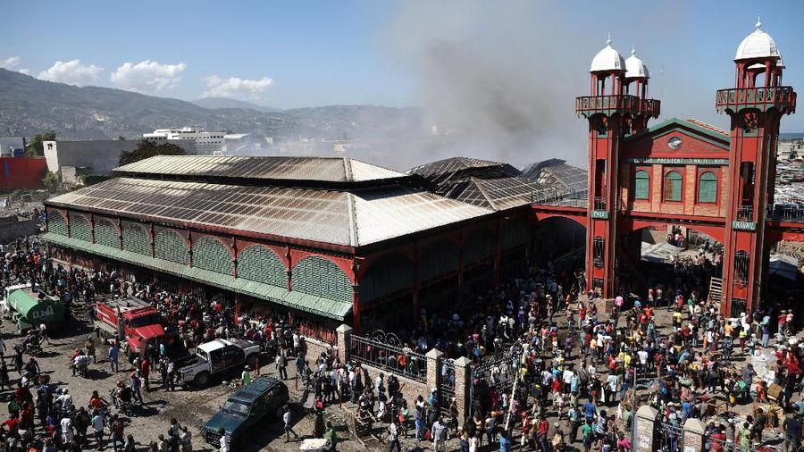 People stand outside of the Marche Hyppolite (Hyppolite Market), also known as Marche en Fer (Iron Market), after a fire that affected part of the market and the surrounding stands in Port-au-Prince, Haiti, February 13, 2018. REUTERS/Andres Martinez Casares