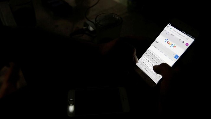 A man use his smartphone, in this picture illustration taken February 14, 2018. Picture taken February 14, 2018. REUTERS/Beawiharta/Illustration
