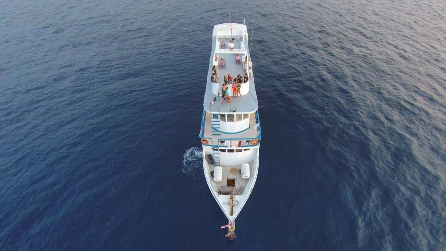 Amazing view to cruise boat sailing in open sea at windy day. Aerial photo drone view - birds eye angle. Cruise boat theme.