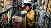 Lebih dari 100 tahun, Perpustakaan Nasional Yunani menempati sebuah bangunan di tengah kota Athena. Kini, perpustakaan 185 tahun itu pindah ke bangunan era modern abad ke-21. Para karyawan dibantu pekerja pun berbenah membereskan koleksi. (AFP/Louisa Gouliamaki)