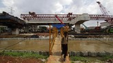 Warga melewati jembatan di samping proyek pembangunan Tol Bekasi-Cawang-Kampung Melayu (Becakayu) di Jalan Kalimalang, Jakarta, Rabu (21). (Eko Siswono Toyudho/Anadolu Agency).