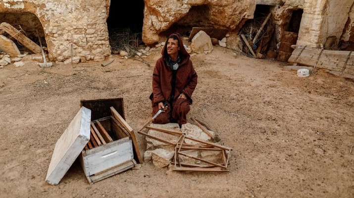rumah bawah tanah Mustapha, 54, a farmer, sits in the corridor of his his family's troglodyte house which was converted to a warehouse, on the outskirts of Matmata, Tunisia, February 4, 2018. REUTERS/Zohra Bensemra SEARCH