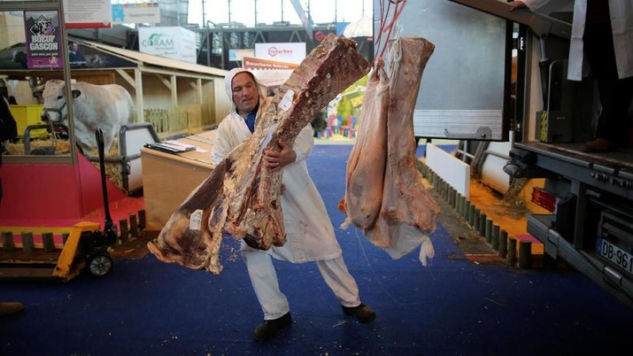 Butchers unload sides of beef at the 2018 Paris International Agricultural Show as farmers and their animals prepare for the opening of the farm show in Paris, France, February 23, 2018.   REUTERS/Stephane Mahe