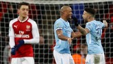 Mesut Oezil tampak kecewa sedangkan Vincent Kompany dan Nicolas Otamendi merayakan keberhasilan Manchester City jadi juara. (Reuters/Carl Recine)
