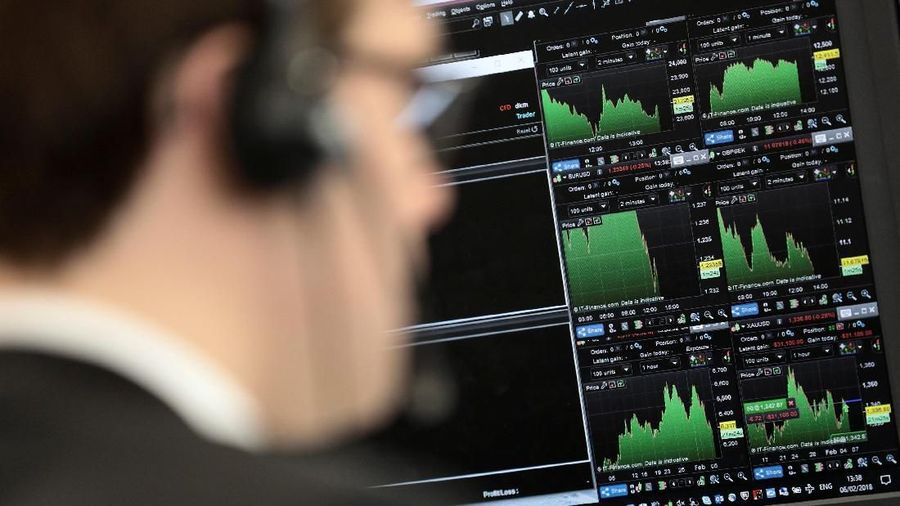 A broker looks at financial information on computer screens on the IG Index trading floor in London, Britain February 6, 2018. REUTERS/Simon Dawson