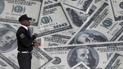 Dollar FILE PHOTO: A security guard walks past a montage of U.S. $100 dollar bills outside a currency exchange bureau in Kenya's capital Nairobi, July 23, 2015. REUTERS/Thomas Mukoya/File Photo