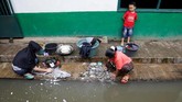 Dua orang ibu rumah tangga mencuci baju mereka di pinggir aliran Sungai Citarum di kawasan Bandung Selatan, 25 Januari 2018. Sungai yang melewati 12 wilayah di Jawa Barat ini dikotori limbah dari mulai pabrik hingga rumah tangga. (REUTERS/Darren Whiteside)