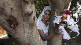 Seorang perempuan yang berpakaian pengantin memeluk sebatang pohon dalam acara pernikahan antara manusia dan pohon. Acara ini digelar untuk meningkatkan kesadaran dan menghentikan pembalakan liar di San Jacinton, Meksiko. (REUTERS/Jorge Luis Plata)
