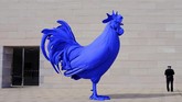 Seorang petugas keamanan berdiri di samping instalasi seni karya Katharina Fritsch yaity patung ayam jago biru. Patung ini terletak di teras Galeri Seni Nasional di Washington, Amerika Serikat. (REUTERS/Kevin Lamarque)