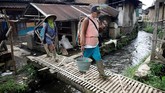 Seorang petani menyebrangi jembatan yang melintasi aliran air dari situ (danau) Cisanti di Desa Tarumajaya, Kabupaten Bandung, 24 Februari 2018. Situ Cisanti adalah titik nol hulu Sungai Citarum. (REUTERS/Darren Whiteside)