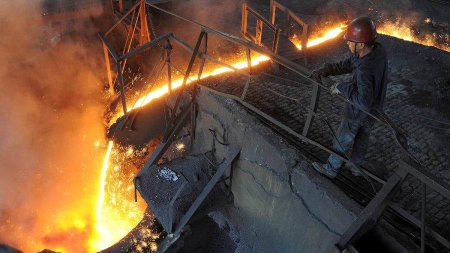 FILE PHOTO: A worker monitors molten iron pouring into a furnace at steel manufacturing plant in Hefei, Anhui province August 15, 2012. REUTERS/Stringer/File Photo