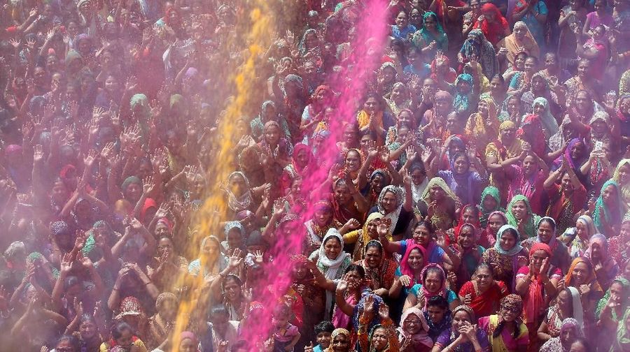 Warna warni pesta Holi Hindu devotees pray as coloured powder is thrown on them by a priest (unseen) at a temple during Holi celebrations in Ahmedabad, India March 3, 2018. REUTERS/Amit Dave
