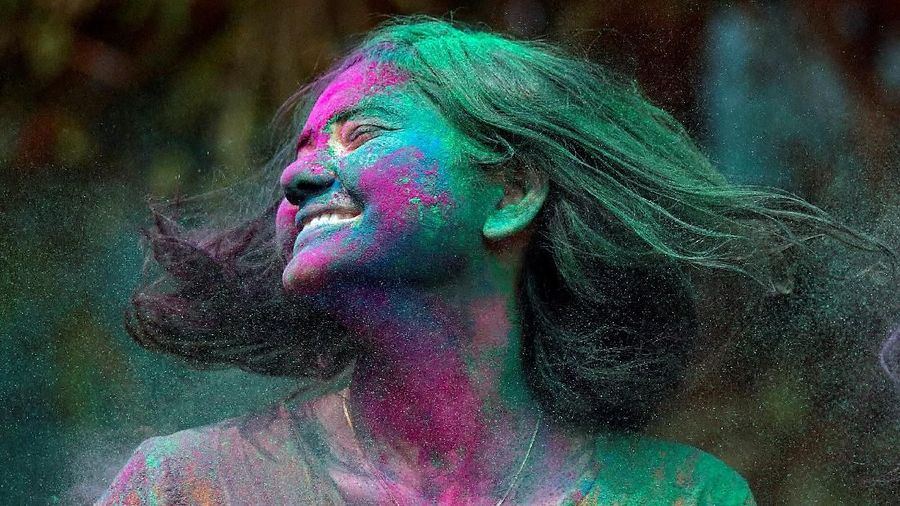 A woman smeared with coloured powder shakes her head to remove it during Holi celebrations in Mumbai, India March 2, 2018. REUTERS/Francis Mascarenhas