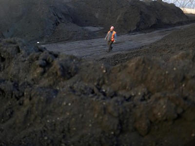 FILE PHOTO: A worker walks past coal piles at a coal coking plant in Yuncheng, Shanxi province, China January 31, 2018. Picture taken January 31, 2018.  REUTERS/William Hong/File Photo