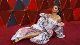 Andra Day menggunakan gaun floral berwarna pink dan biru dengan detail kerut di bagian depannya. Detail off shoulder dan lengan puff dari Zac Posen ini terlihat cukup aneh. (REUTERS/Carlo Allegri)