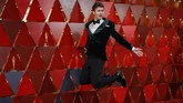 Ansel Elgort memilih gaya tuksedo yang berbeda dari biasanya. Meski masih berwarna gelap namun dia memilih tuksedo warna hijau lumut yang berbahan velvet. (REUTERS/Carlo Allegri)