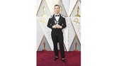 Si 'bad boy' Adam Rippon tampil pertama kali di panggung Oscar. Dia menggunakan kemeja putih dengan tuksedo modifikasi dari Moschino. Dia menambahkan fashion statement dengan menambahkan strap kulit harness di bagian dalamnya. (Frazer Harrison/Getty Images/AFP)