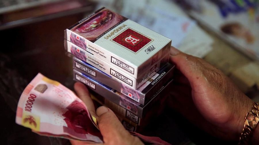 A woman buys packs of Sampoerna-A mild cigarette at a shop in Jakarta, Indonesia, March 6, 2018. REUTERS/Beawiharta