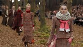 Tak hanya penuh pepohonan, hutan buatan itu juga diisi oleh berbagai dedaunan sebagai 'karpet', sehingga para model yang berjalan beriringan seperti sedang berjalan benar-benar di tengah hutan. (REUTERS/Pascal Rossignol)