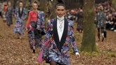 Di antara para model yang tampil, Kaia Gerber cukup mencolok dengan mini dress hitam renda, sarung tangan pink, tas tangan pink berukuran besar, dan anting kiri dan kanan yang tak sama. (REUTERS/Pascal Rossignol)