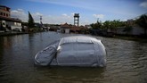 Sebuah mobil yang ditutup kover sebagian badannya terendam air laut yang naik di kawasan Muara Baru, Jakarta, 6 Desember 2017. Kenaikan air laut dan abrasi sebetulnya bisa dicegah alami dengan hutan mangrove, namun hal tersebut kini makin menipis seiring kebutuhan lahan masyarakat. (REUTERS/Beawiharta)
