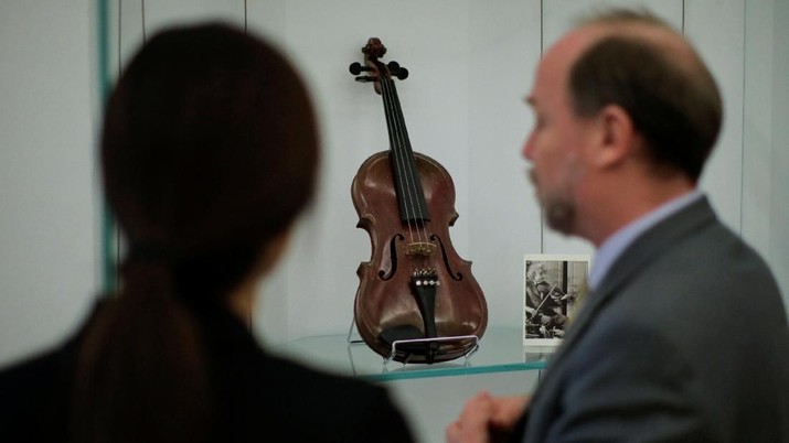 People take a look at Albert Einstein's violin which will be out for auction at Bonhams auction house in New York, U.S., March 6, 2018. REUTERS/Eduardo Munoz
