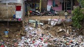 Seorang anak terlihat di samping sampah-sampah yang dibuang di tepi sungai di salah satu sudut DKI Jakarta, 10 Januari 2018. (AFP PHOTO / BAY ISMOYO)
