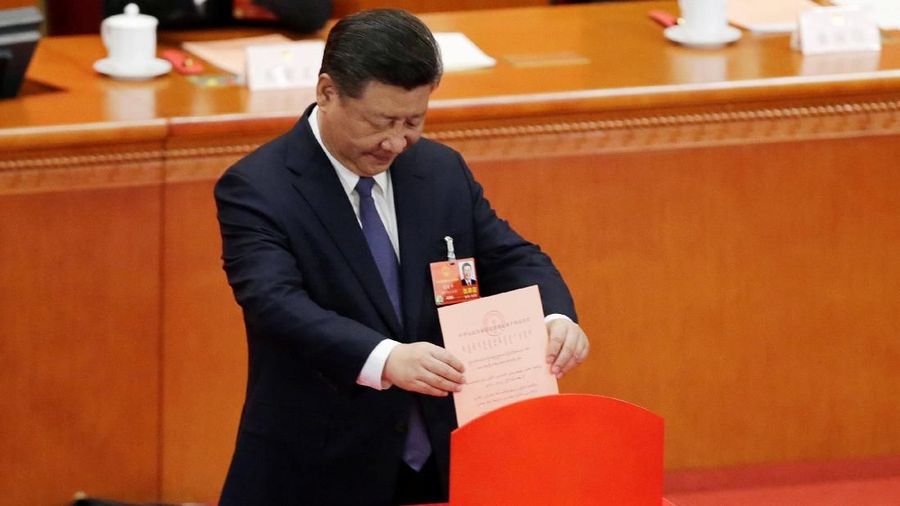 Chinese President Xi Jinping drops his ballot during a vote on a constitutional amendment lifting presidential term limits, at the third plenary session of the National People's Congress (NPC) at the Great Hall of the People in Beijing, China March 11, 2018.