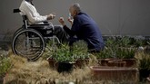 Seorang tahanan berusia 92 tahun yang sudah tak bisa berjalan duduk di kursi roda sambil mendapatkan arahan dari seorang perawat. (REUTERS/Toru Hanai TPX IMAGES OF THE DAY)