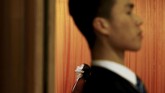 Seorang pengunjung dan petugas keamanan berdiri di pintu masuk menuju aula ketika digelarnya sesi keempat Kongres Rakyat Nasional (NPC) di Beijing, China. (REUTERS/Thomas Peter)