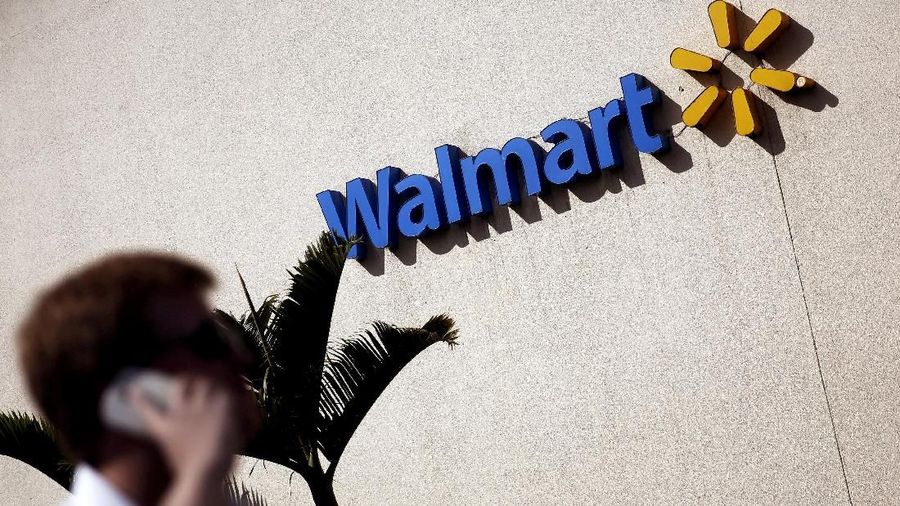 FILE PHOTO: A man talks on his mobile phone in front of a Wal-Mart store in Sao Paulo, Brazil, February 16, 2016.  REUTERS/Nacho Doce/File Photo