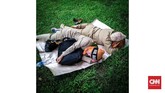 Dua pedemo merebahkan tubuh tidur di Taman Monas, Jakarta. Tidur yang berkualitas memiliki pengaruh besar pada kualitas kesehatan fisik dan mental. (CNNIndonesia/Safir Makki)