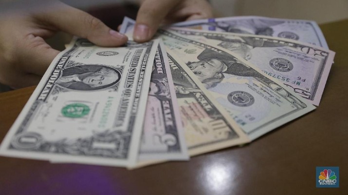 Karyawan menunjukkan pecahan uang dollar di salah satu tempat penukaran uang di kawasan Blok M, Kebayoran Baru, Jumat (16/3/2018). (CNBC Indonesia/Muhammad Sabki)
